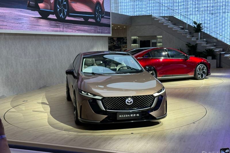 The Changan Mazda EZ-6, unveiled at the 2024 Beijing Auto Show, is a joint venture D-segment electric car. It features Mazda's signature design, illuminated Mazda emblem, hidden door handles, 19-inch aerodynamic alloy wheels, and an upscale interior with Alcantara and matte chrome accents.